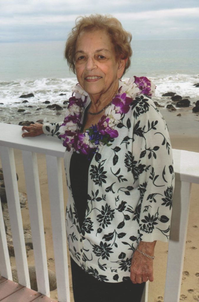 Older woman wearing lei on beach